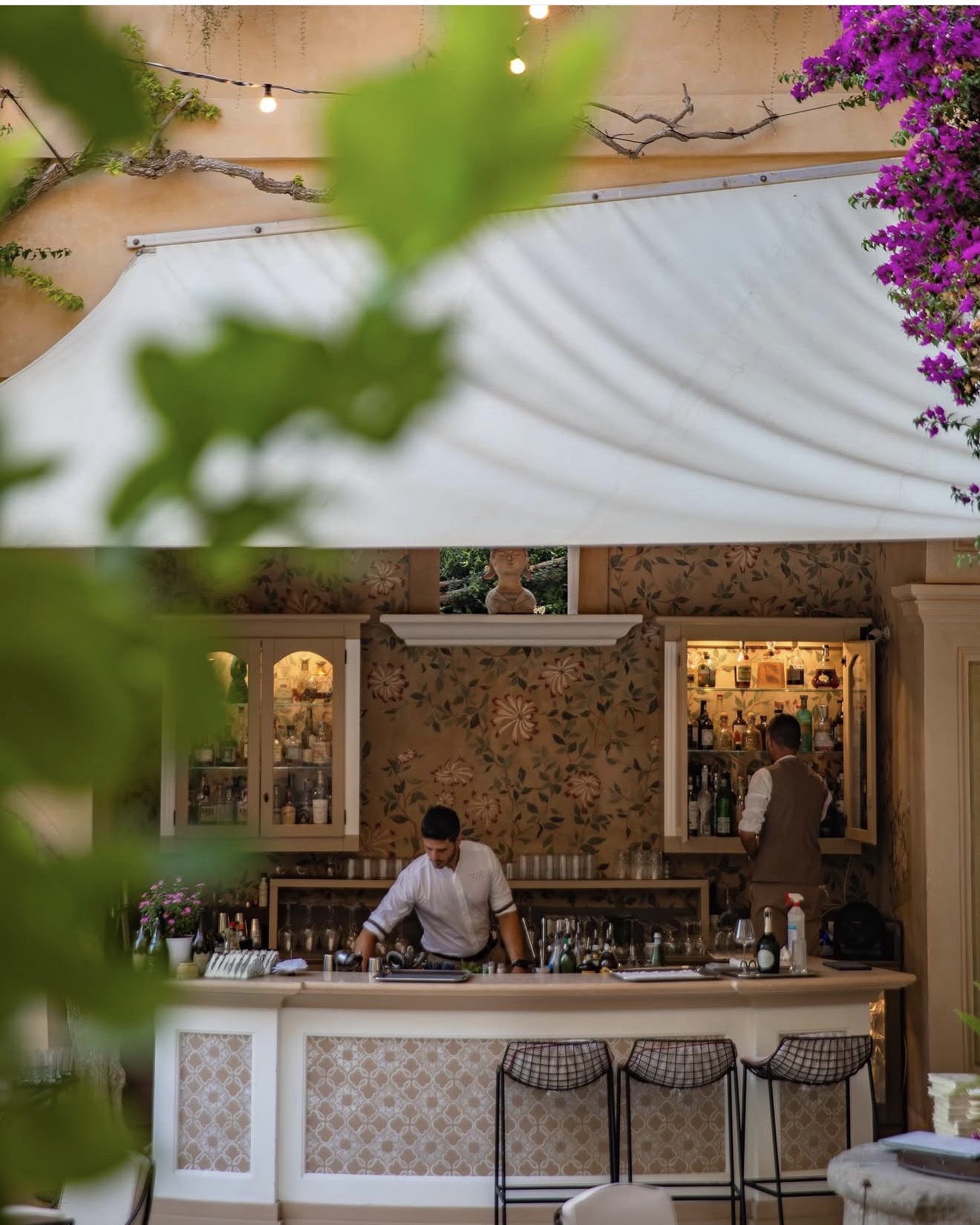 Le Petit Murat Lounge Bar courtyard with greenery and bougainvillea